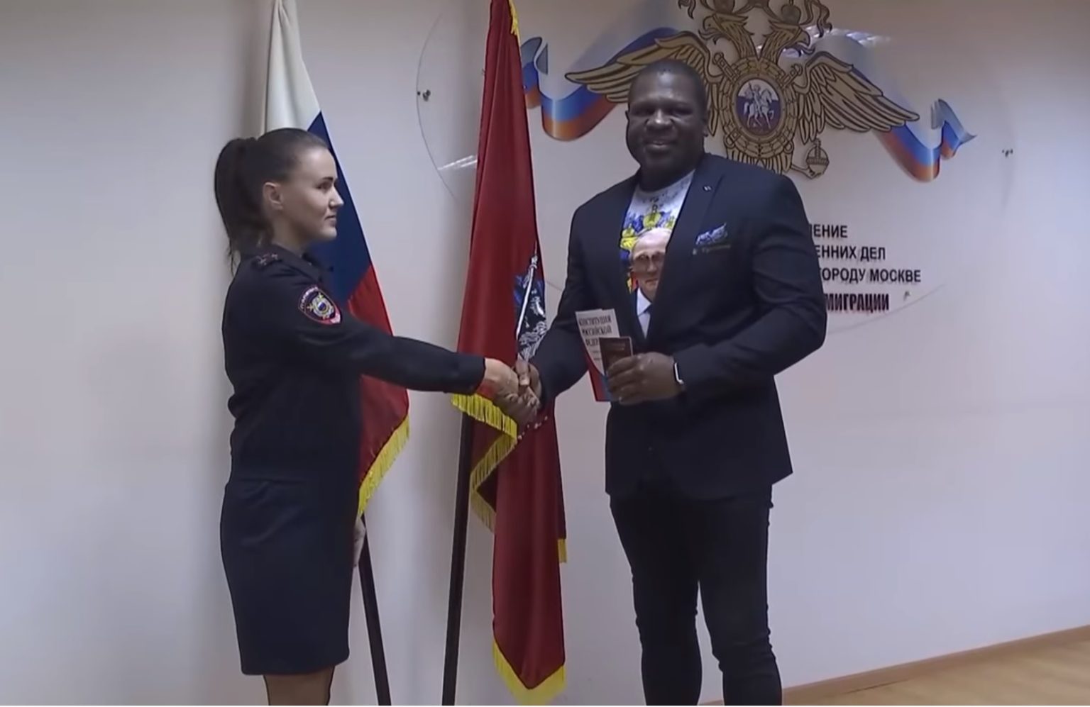 بقميص يحمل صورة بوتين.. الملاكم الأميركي كيفن جونسون يتسلم جواز السفر الروسي